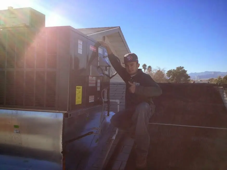 HVAC technician performing AC Tune-Up on a rooftop unit in Middlesex
